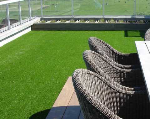 vibrant fake grass laid on balcony with view of farm land