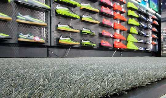 artificial grass laid in sport store with football boots